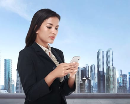 Beautiful asian business woman holding smartphone with cityscape background.