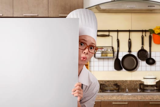 Young asian woman chef standing from behind white board on kitchen room