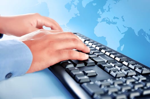 Businessman hand typing on keyboard against blue globe background