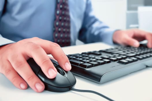 Businessman using computer with hands typing on a keyboard in the office