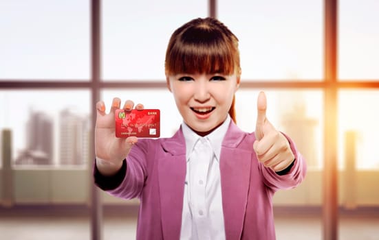 Beautiful asian business woman give thumbs and showing credit card in the office