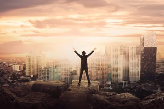 Back view of asian business woman celebrating success over cityscape background