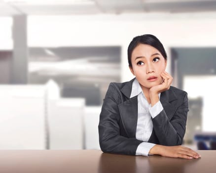 Young asian business woman working at office desk and thinking something on the office