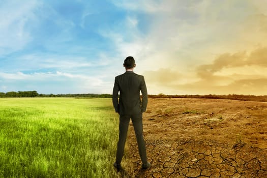 Asian businessman standing between different climate on the daylight