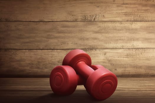 Pair of red dumbbells for workout on wooden rustic background
