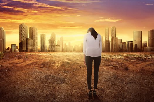 Rear view of asian business woman with sad expression looking changing environment in the modern city