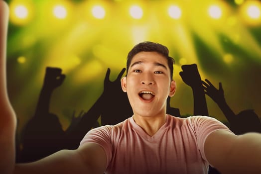 Happy asian man selfie with the crowd at music performance