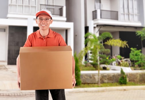 Smiling asian courier delivering the package in the city