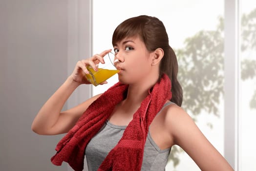 Happy asian woman drink natural orange juice at home
