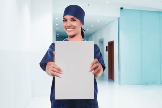 Happy asian woman nurse showing empty white board in a hospital