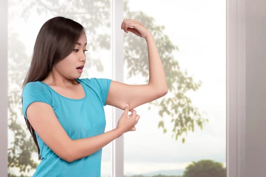 Young asian women weight loss on her arm with window glass background
