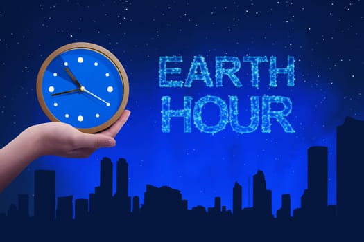 People hand holding a clock with earth hour greeting against a background night scene