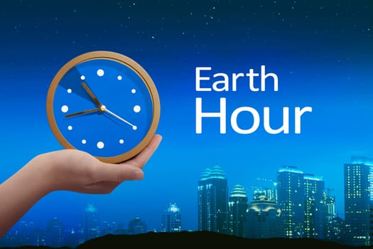 People hand holding clock with earth hour greeting against night scene background