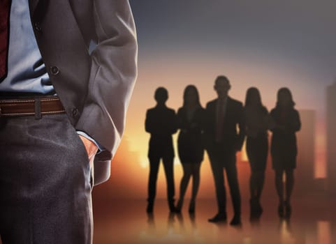 Business man with silhouettes of group business people on a cityscape background