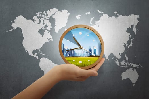 People hand holding clock with world map on gray background
