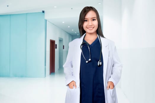 Asian female doctor smiling over hospital background