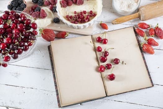 cookbook with ingredients and red fruits