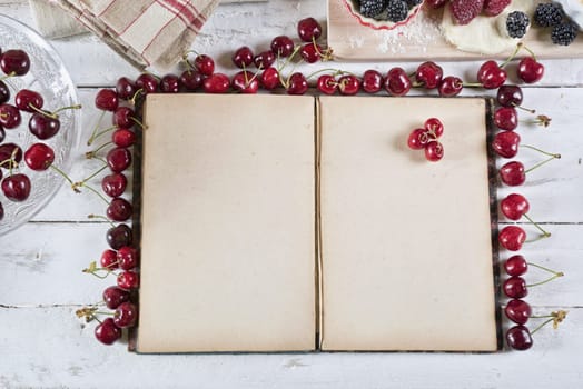 cookbook with ingredients and red fruits