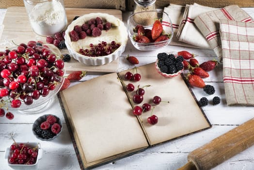 cookbook with ingredients and red fruits