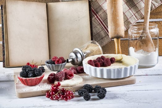 cookbook with ingredients and red fruits