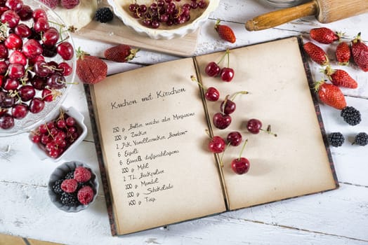 cookbook with ingredients and red fruits