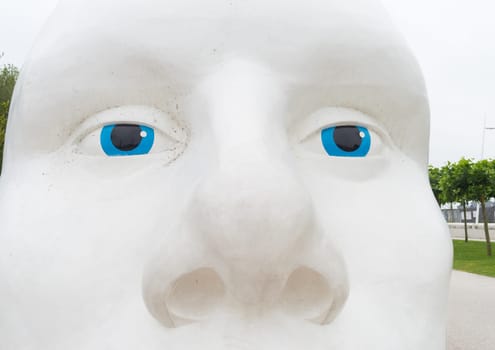 LELYSTAD, NETHERLANDS - AUGUST 7, 2016: closeup of a statue of a white head with blue eyes, made by Henk Hofstra