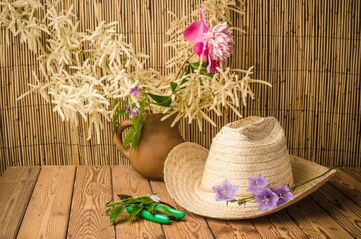 Straw hat and flowering campanula, close-up