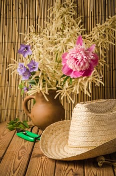Straw hat and peony flower, close-up