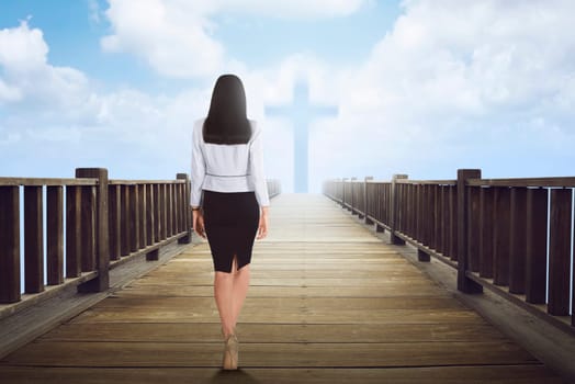 Back view of asian woman walking to cross shape on the cloud