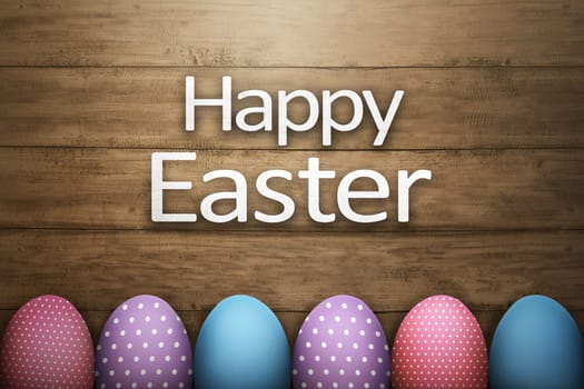 Row of easter egg with Happy Easter greeting against wooden plank background