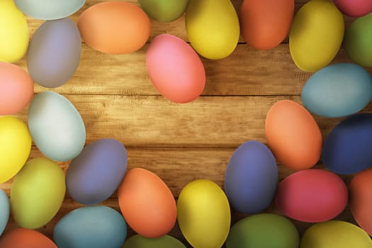 Colorful easter eggs on wooden floor background with space