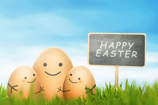 Happy Easter eggs with sign on a grass field with blue sky