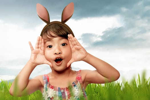 Asian girl with bunny ears on easter day in the meadow