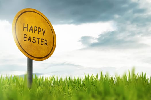 Happy Easter greeting on traffic sign in a grass field with blue sky