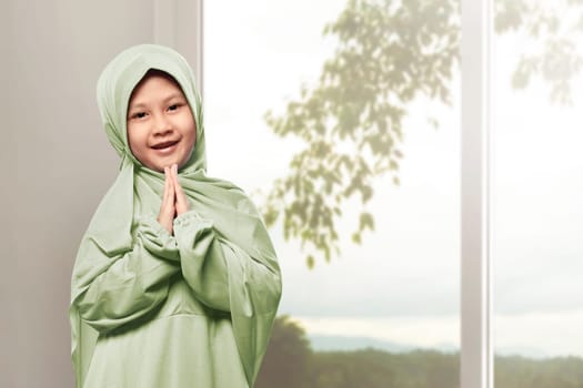 Asian muslim girl wearing hijab praying in the home