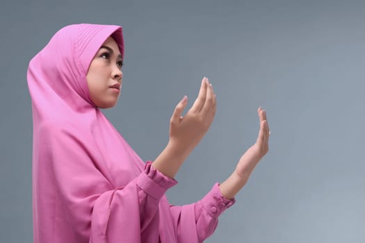 Asian muslim woman wearing traditional clothes praying with abstract background