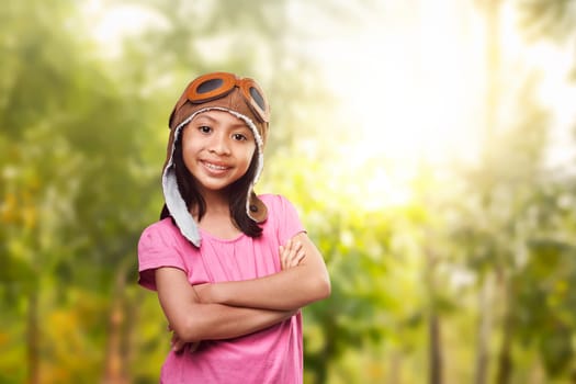 Cheerful asian kid having fun with aviator costume on the park