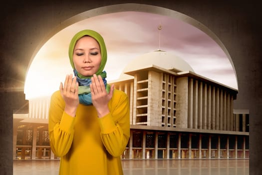 Young asian muslim woman praying in the mosque
