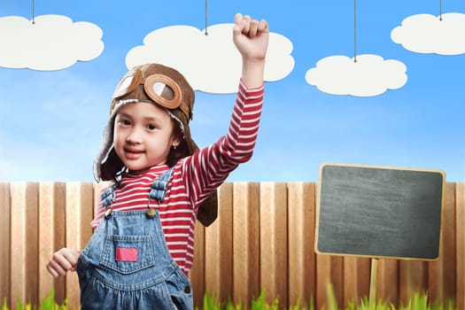 Happy asian child in aviator costume is playing and having fun on funny background