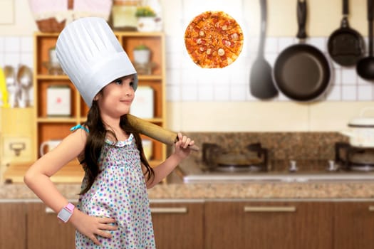 Asian little girl with rolling pin thinking to make pizza on the kitchen