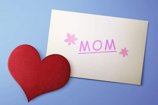 Mothers Day message on paper with red hearts against blue background