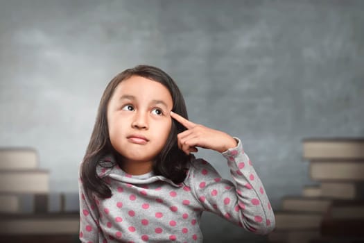 Funny asian kid thinking for new inspiration in the school