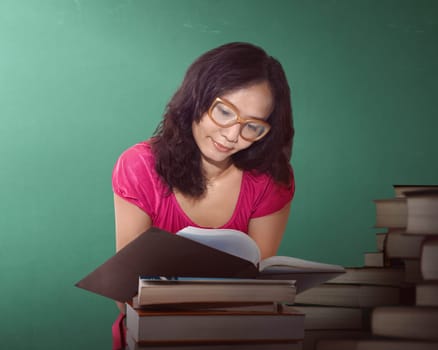 Asian woman reading a book at a library with green background