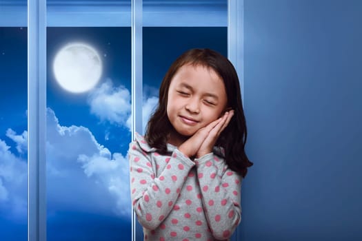 Funny asian kid sleeping on her hand in the home at night
