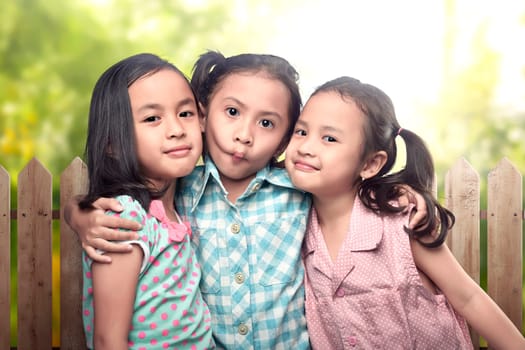 Image of three asian little girl having fun and playing together in the park