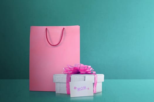 Shopping bag with gift box with pink ribbon for mom. Mother's Day Concept.