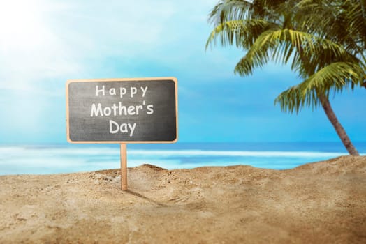 Happy Mothers day greeting on wooden sign in the beach