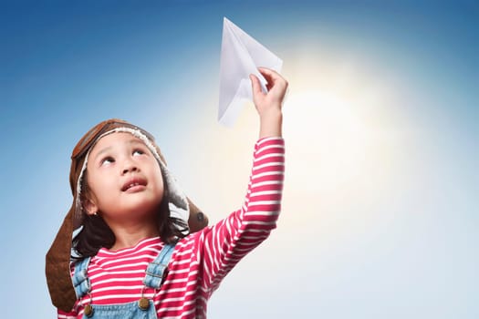 Happy asian kid with toy paper plane having fun at outdoor