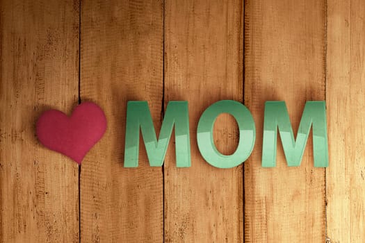 Mom text with heart shape on the wooden wall. Mother's day concept.