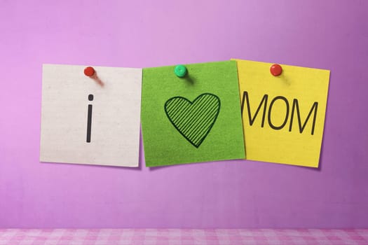 Happy Mothers Day message written on note paper in pink wall background